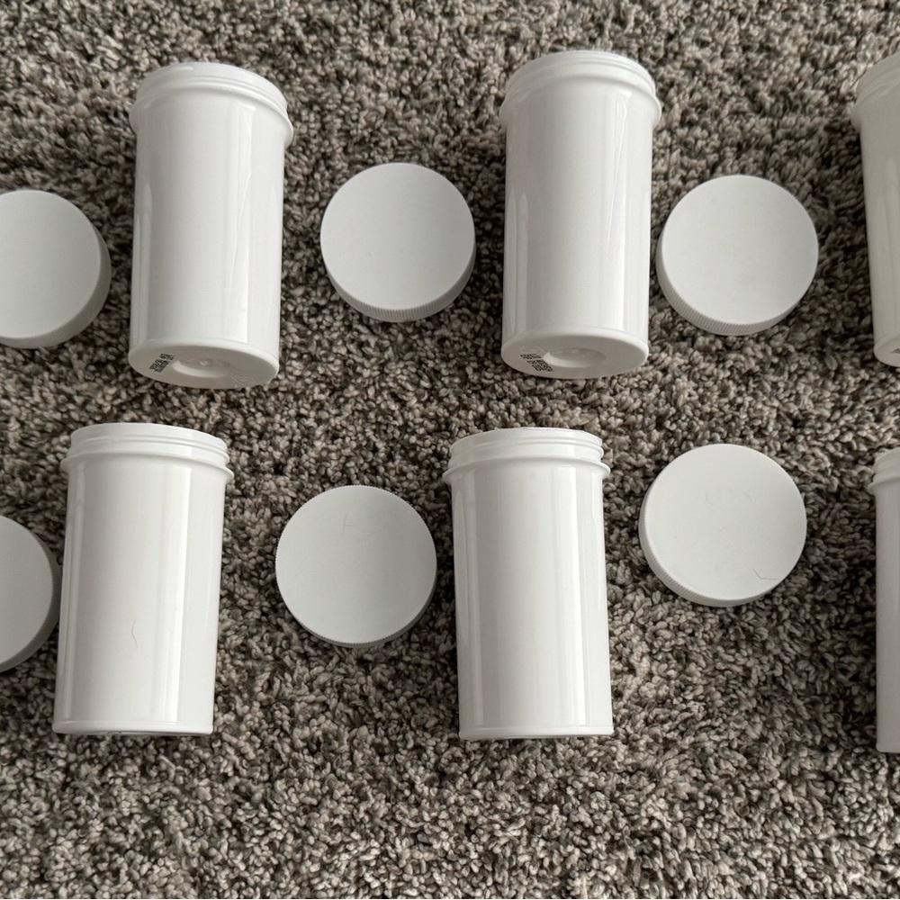 8 white heavy duty, plastic screwtop containers approximately 4 in x 2 in